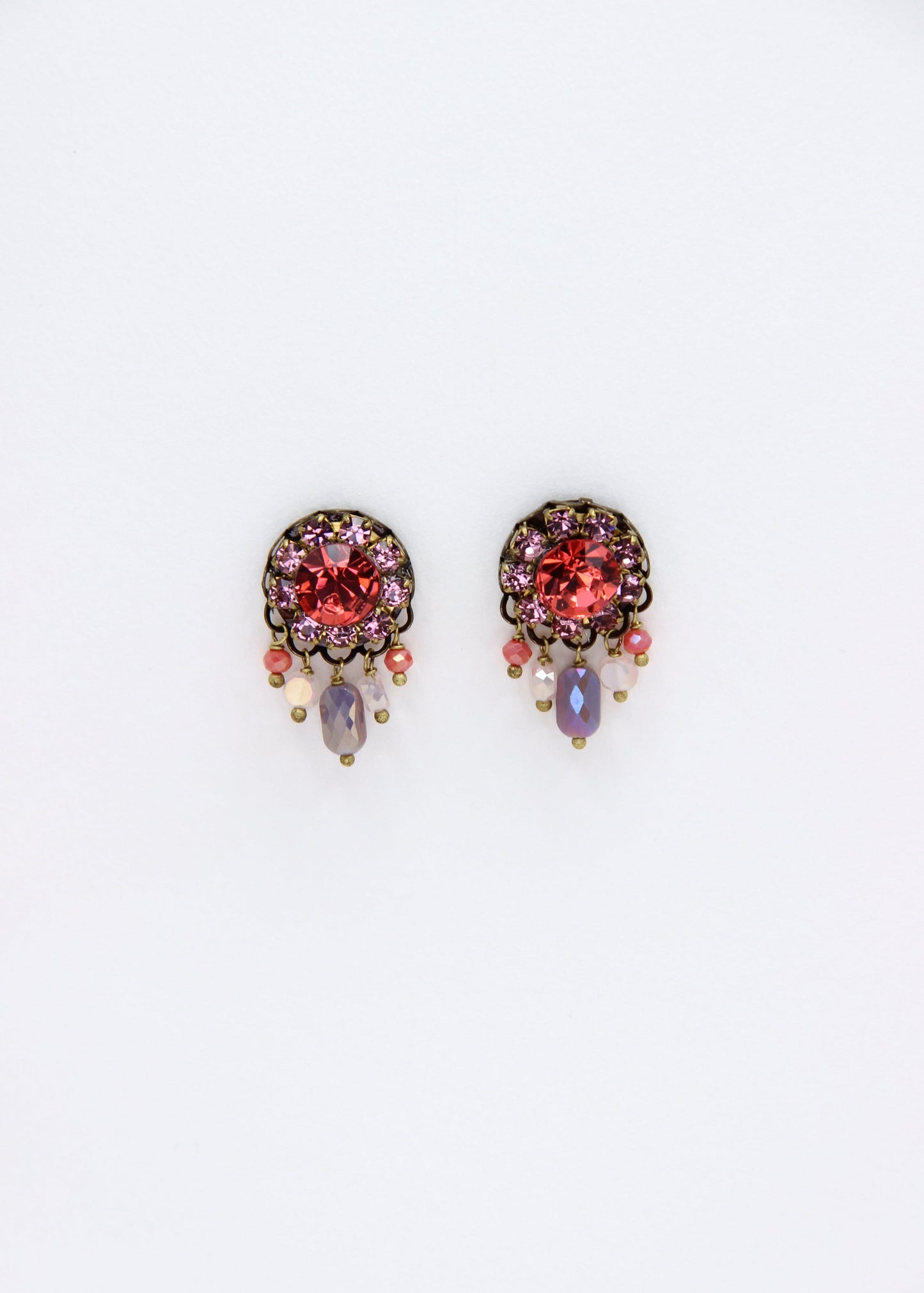 Orecchini artigianali Metropolitan Taormina rosso e malva, con cristallo centrale rosso, corona di strass malva e cinque pietre sfaccettate iridescenti a cascata. Nickel free, stile mediterraneo per ogni occasione.