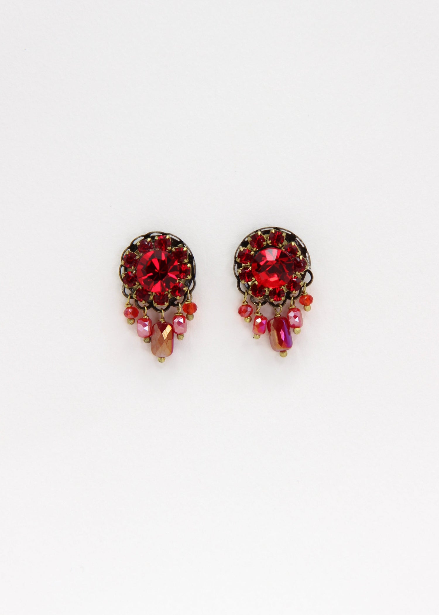Orecchini artigianali Metropolitan Taormina rosso, con cristallo centrale, corona di strass e cinque pietre sfaccettate a cascata in rosso iridescente. Nickel free, stile mediterraneo per ogni occasione.